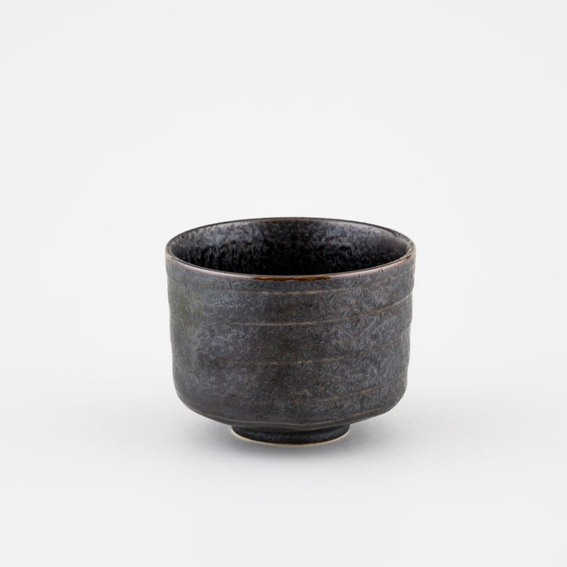 Dark ceramic cup on a light gray background