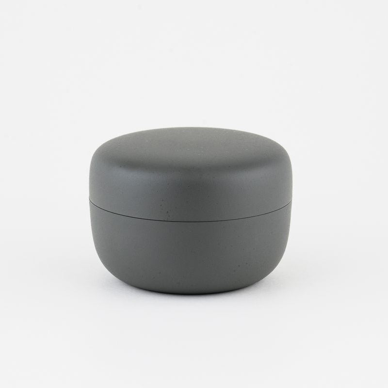 Gray round tea container with lid on a white background