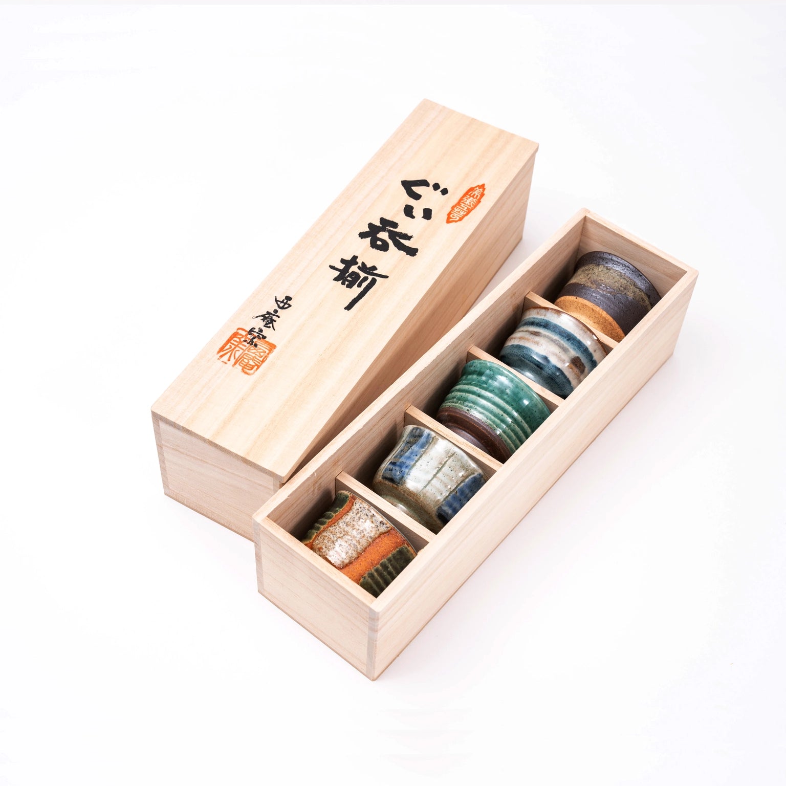 Set of sake set cups in a wooden box on a white background