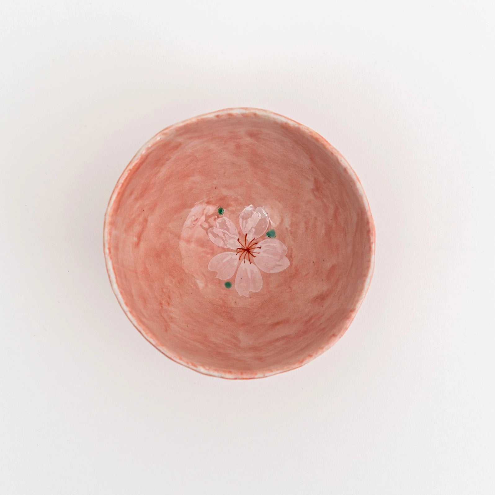 Pink ceramic bowl with a floral design on a light background