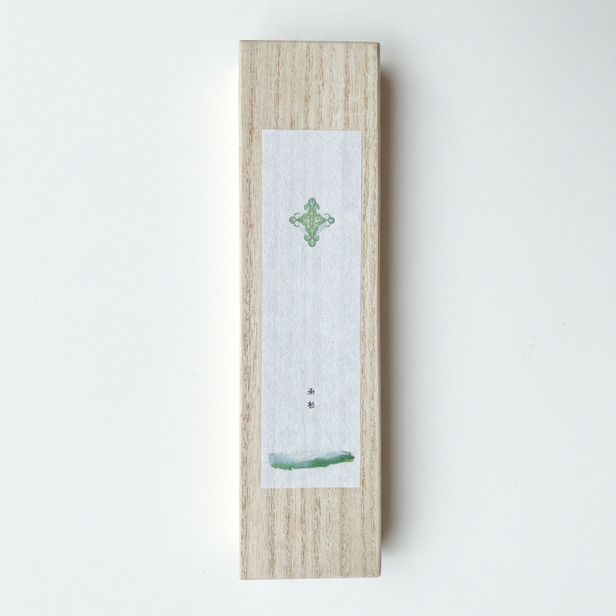 Wooden box with a small white card featuring a green design on a light gray background