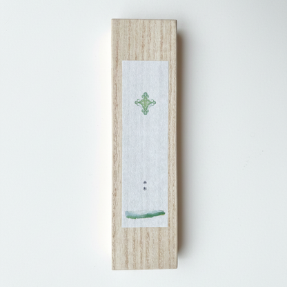 Wooden box with a small white card featuring a green design on a light gray background