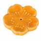 A glossy, five-petal flower-shaped ceramic incense holder in a warm orange-yellow glaze, featuring a central hole and subtle white floral details, set against a plain white background.