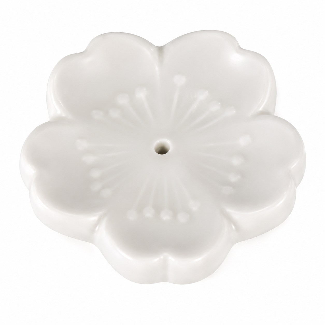 A white ceramic flower-shaped incense holder with a central hole, featuring embossed petal details and a smooth glossy finish, set against a plain white background.