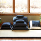 Set of blue patterned cushions on a tatami mat in a room with large windows.