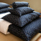 Stack of blue patterned pillows on a shikifuton bed.