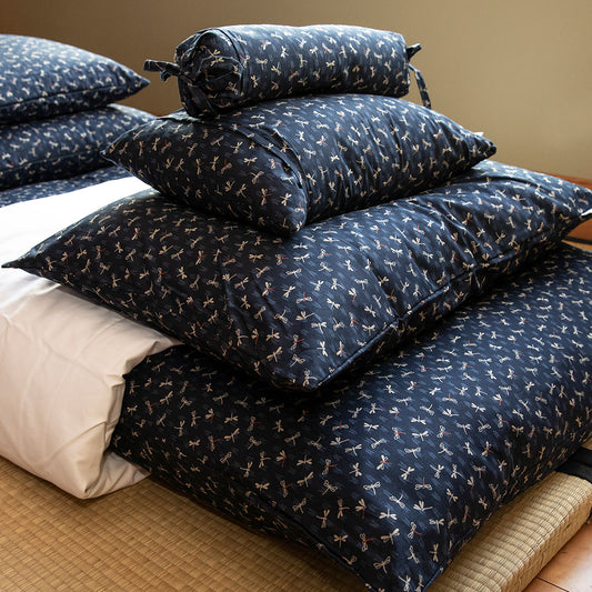 Stack of blue patterned pillows on a shikifuton bed.