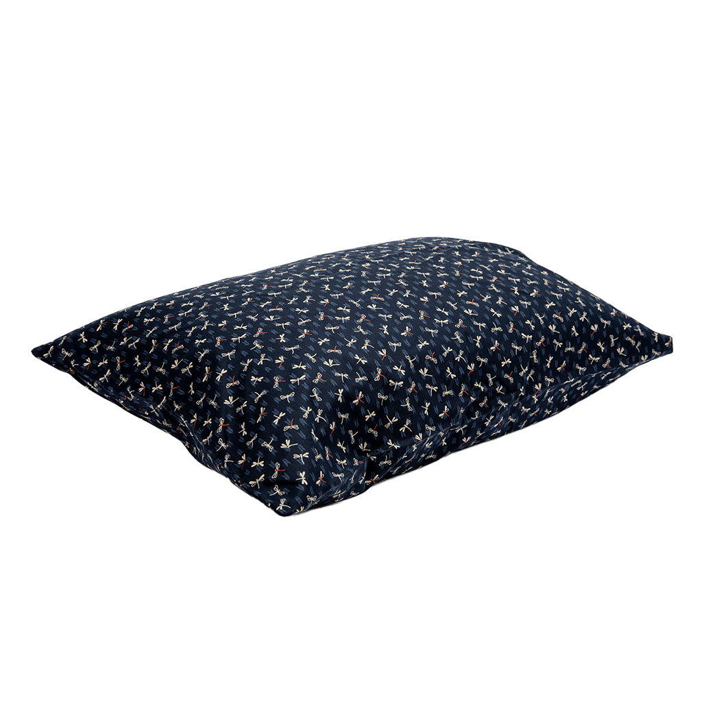 Navy blue pillow with small dragonfly patterns on a white background