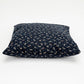 Navy blue pillow with white dragonfly pattern on a white background