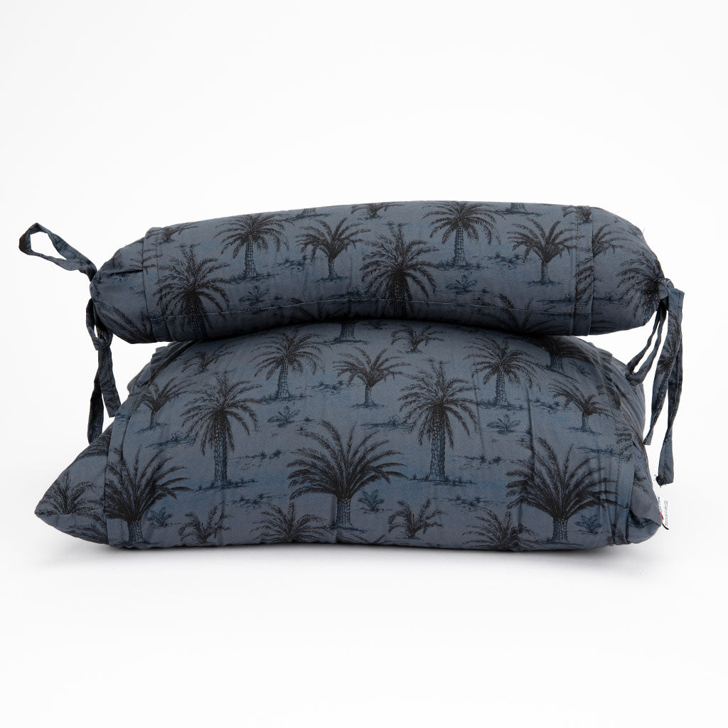 Two rectangular buckwheat pillows stacked on top of each other, featuring a dark blue-gray background with a black palm tree pattern, shown against a plain white background.
