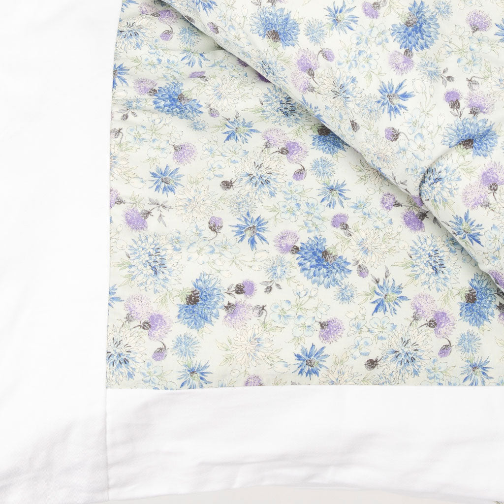 Detail image of a kakefuton duvet cover with soft purple, blue, and white floral details.