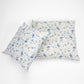 Two rectangular decorative pillows with a delicate blue and purple floral print on a cream background, arranged on a clean white studio background.
