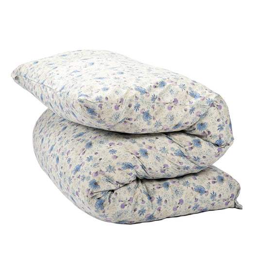 A shiki futon mattress folded with a small blue and purple floral pattern on a light beige background, isolated on a white background.