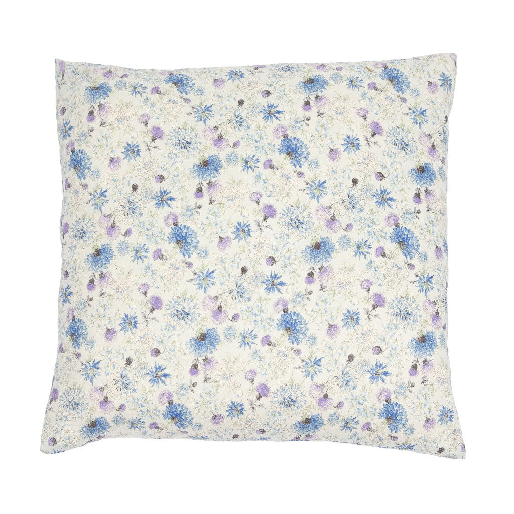 A square decorative throw pillow featuring a delicate floral print with blue and purple flowers on a warm cream background, shown against a plain white studio backdrop.