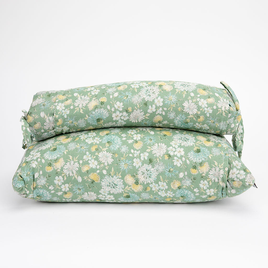 Two buckwheat hull pillows stacked on top of each other, featuring a sage green floral pattern with white, yellow, and light blue flowers, set against a plain white background.