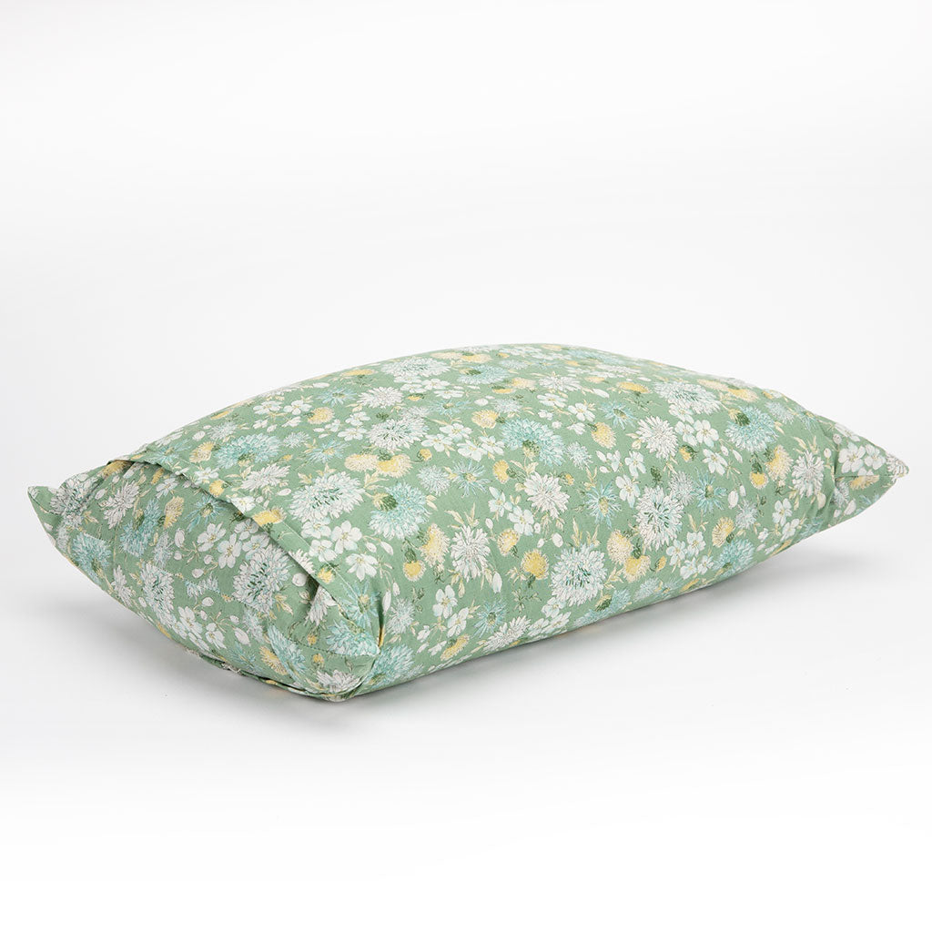 A rectangular buckwheat hull pillow with a sage green floral pattern, featuring white and yellow flowers, photographed on a seamless white background.