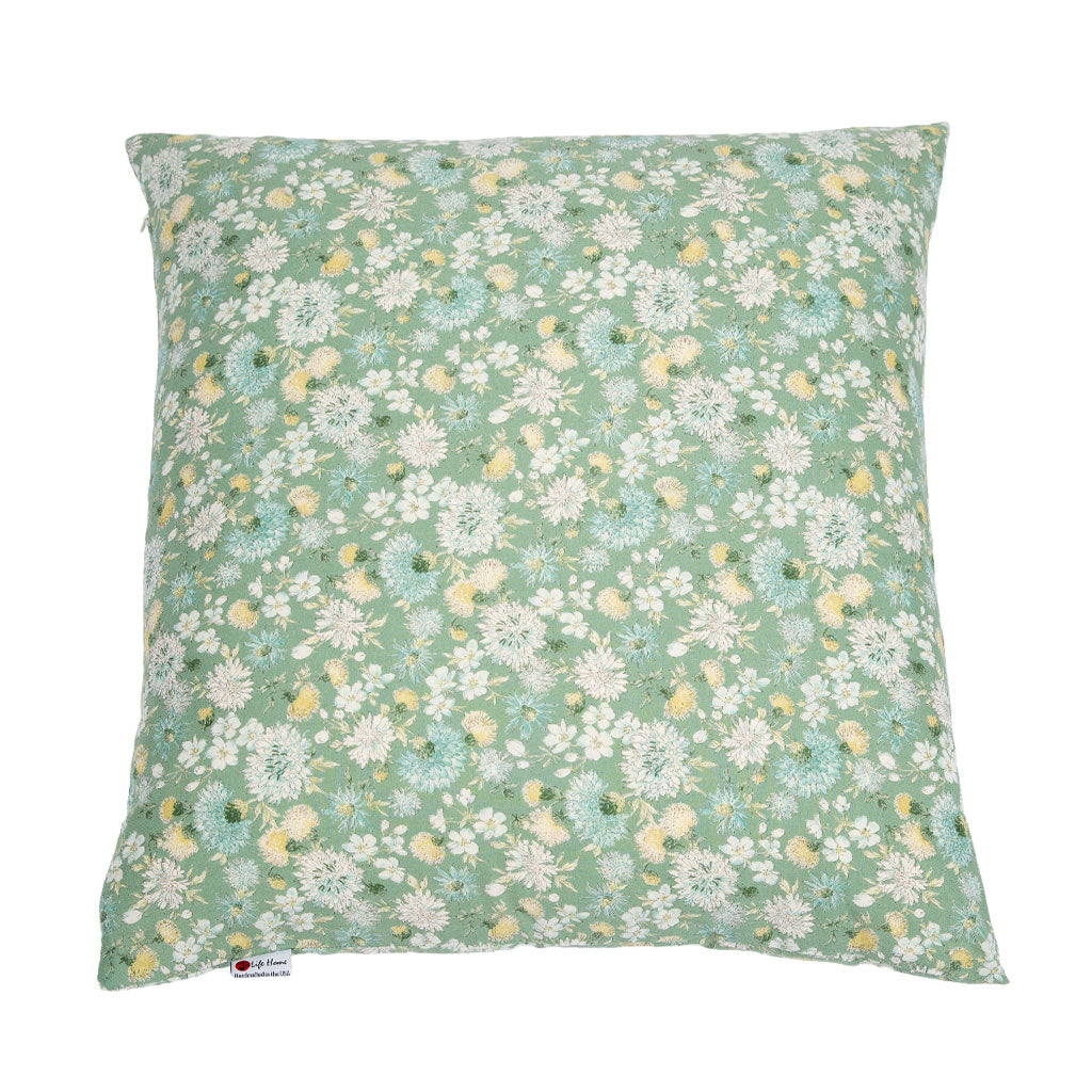 A square decorative throw pillow featuring a dense, all-over floral print in sage green, white, light blue, and soft yellow, shown against a plain white background.