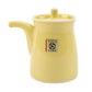 Yellow ceramic soy sauce dispenser with a brand label on a white background