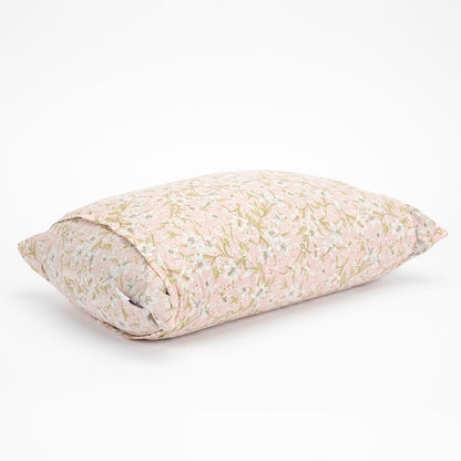 A rectangular buckwheat hull pillow with a light pink and beige floral pattern, shown on a clean white background.
