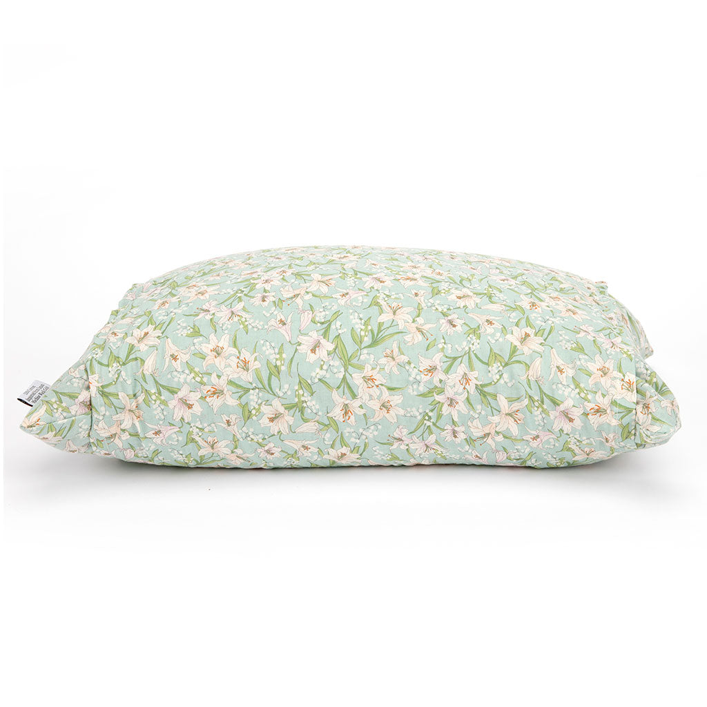 A rectangular buckwheat hull pillow with a light mint green background and a delicate white and pale yellow floral print, shown on a clean white background.