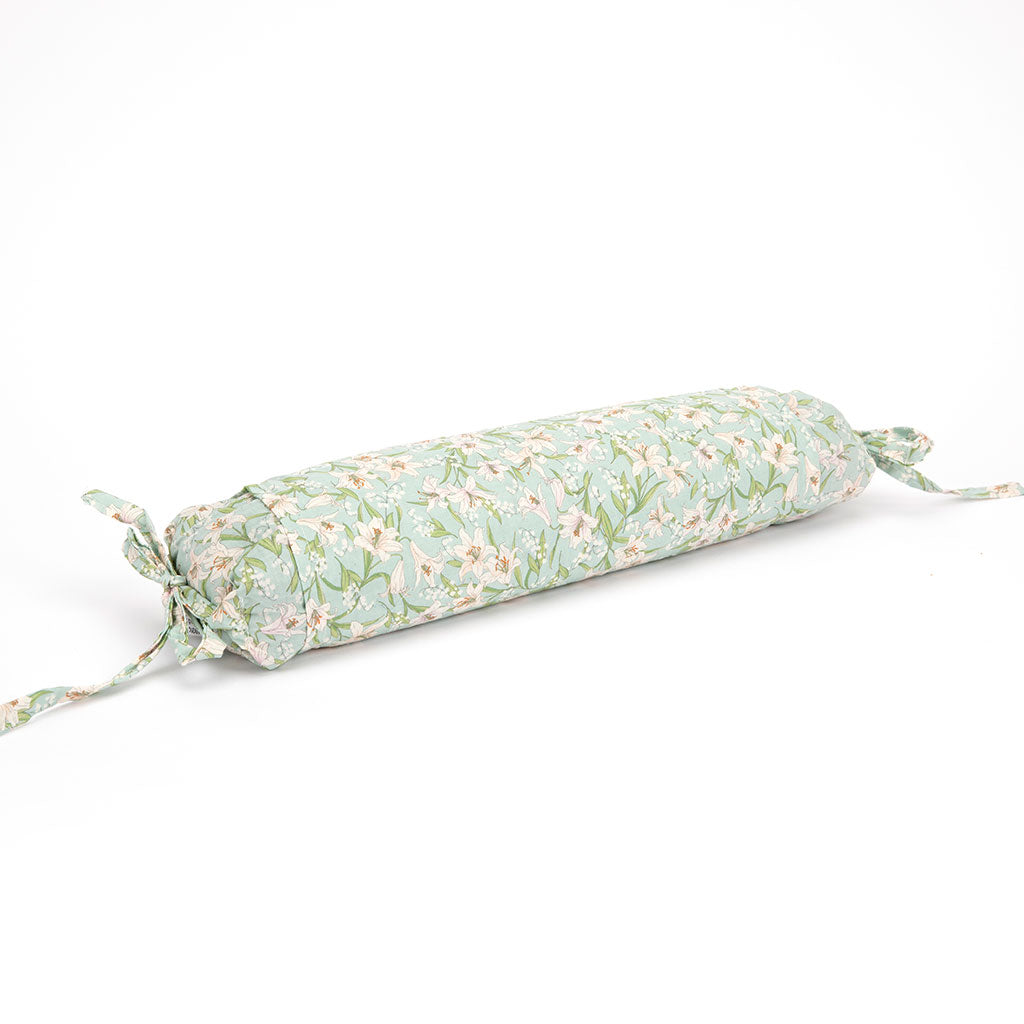 A cylindrical rectangular pillow with a light green and white floral pattern, featuring tie-on ends, shown on a plain white background.