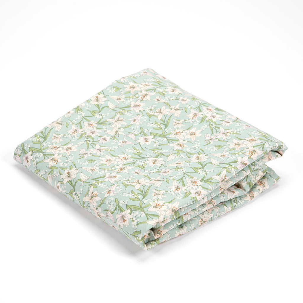 A folded kakefuton duvet featuring a delicate floral pattern in sage green, white, and soft pink on a clean white background.
