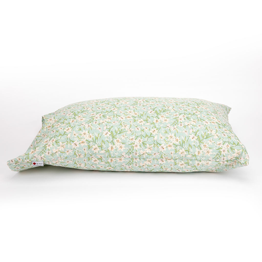 A square decorative pillowcase with a delicate floral print in sage green, white, and soft pink, shown on a clean white background.