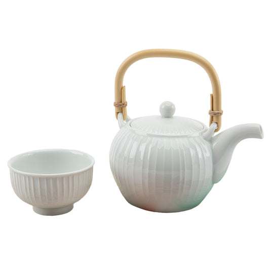 White ceramic teapot with a bamboo handle and matching bowl on a white background