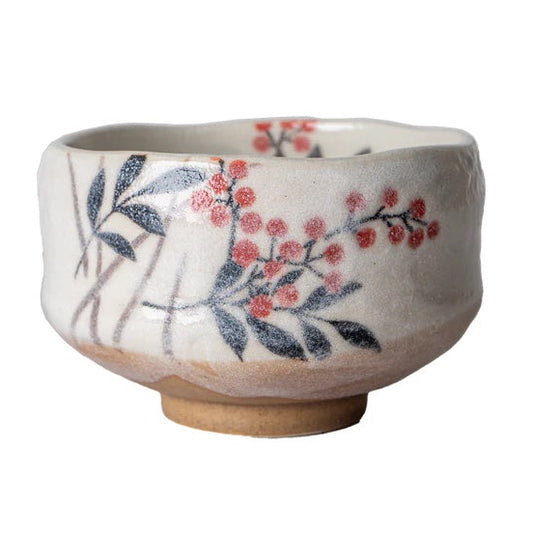 A handmade ceramic tea bowl with a textured off-white glaze, decorated with hand-painted dark blue leaves and red berries, shown on a plain white background.