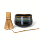 Ceramic matcha bowl with bamboo whisk and spoon on a white background