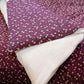 Purple fabric with white floral pattern and white fabric underneath
