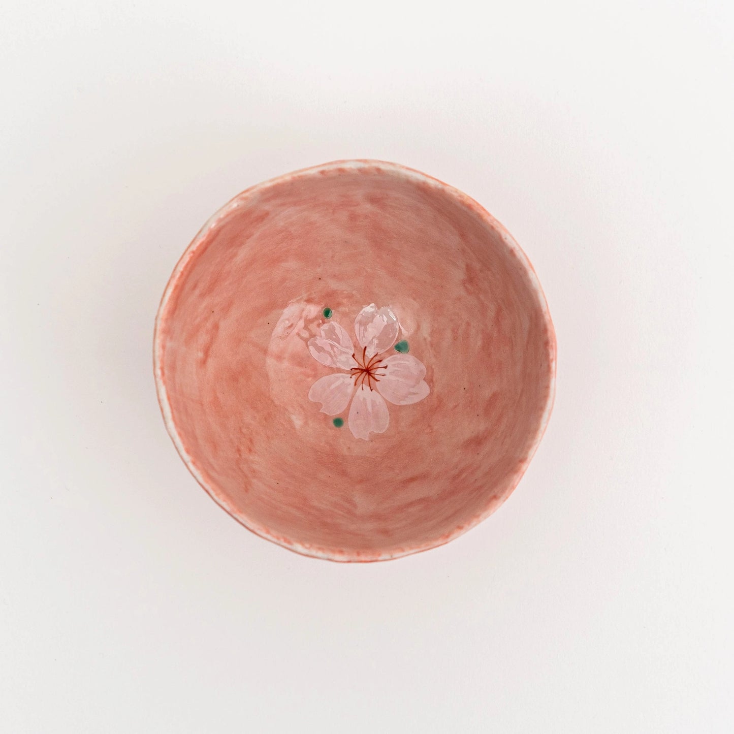 Pink ceramic bowl with a floral design on a light background