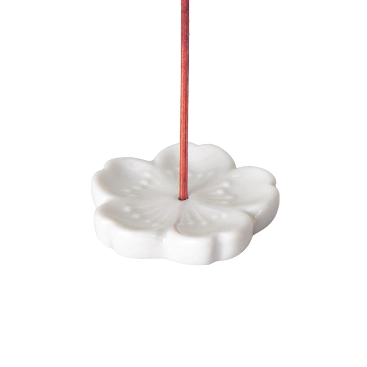 Sakura flower incense holder in white on a white background.