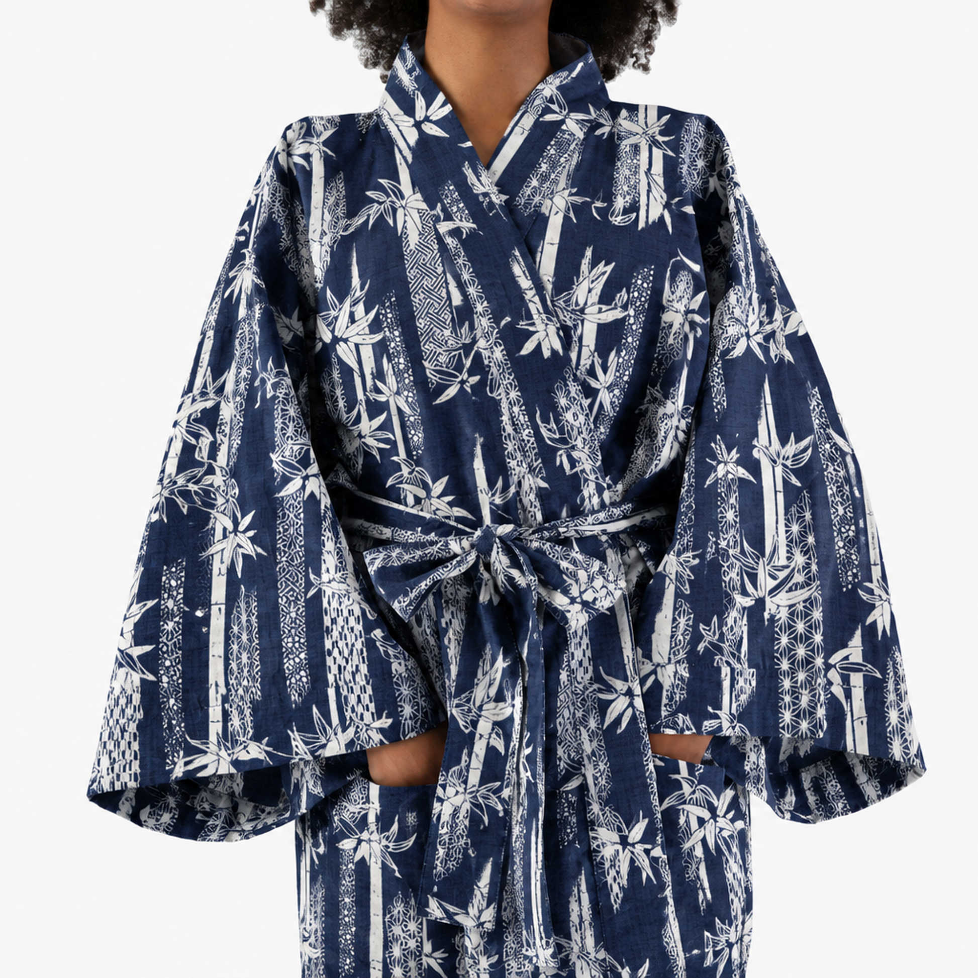 A person wearing a navy blue kimono-style robe with a white tropical and geometric bamboo print, shown against a plain light gray background.