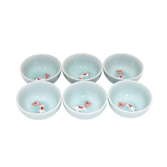 Set of six small ceramic bowls with fish design on a white background