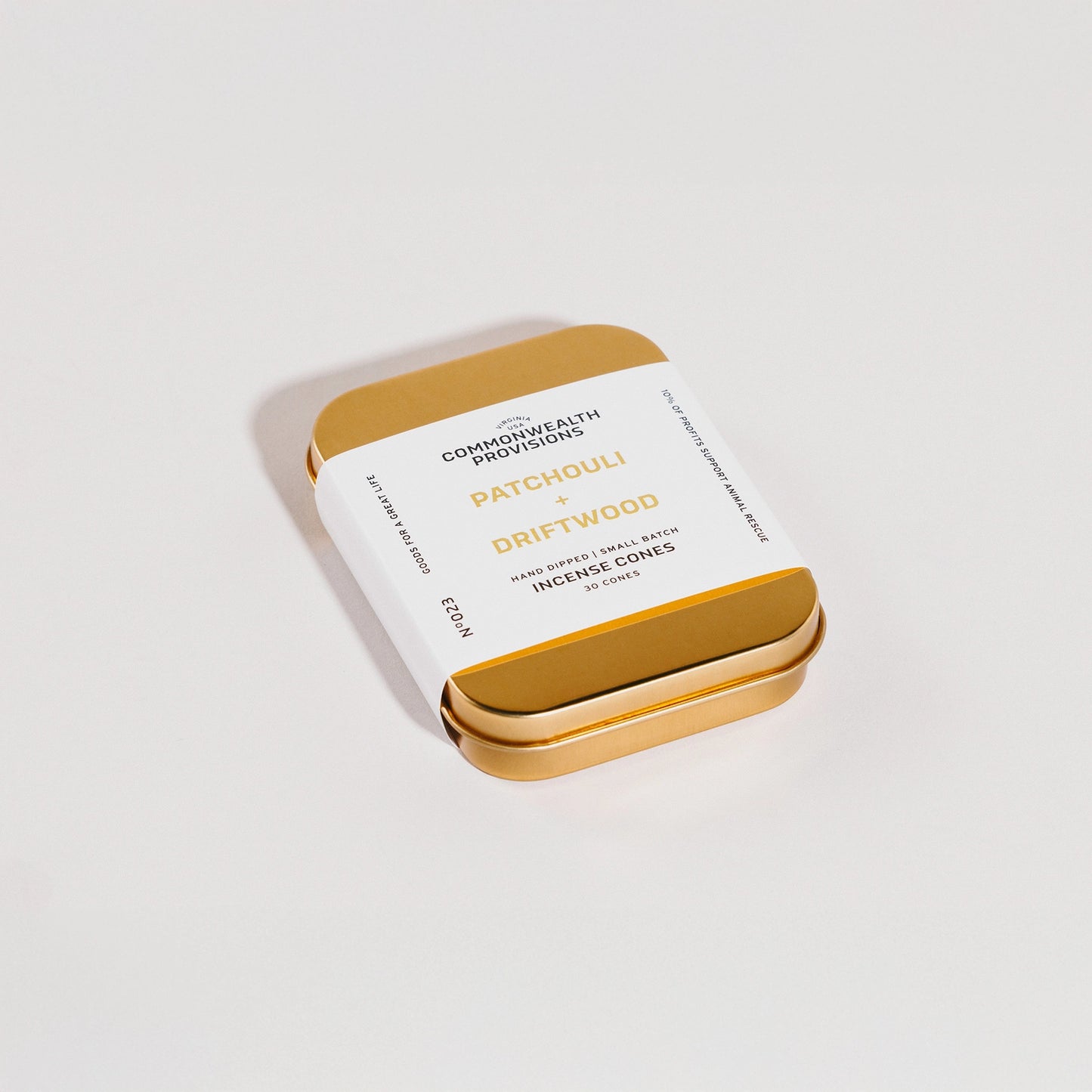 Gold tin packaging with white label on a light gray background